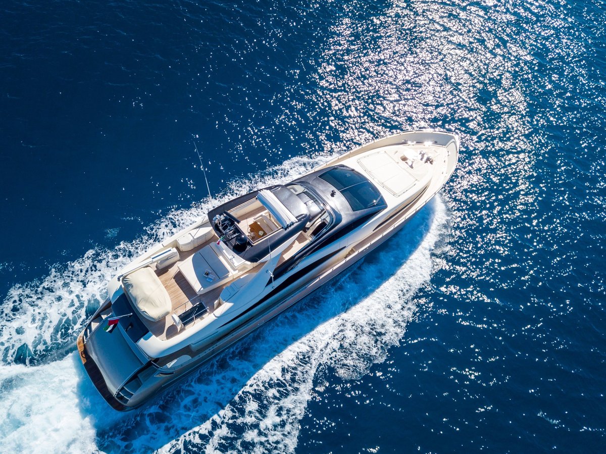 An aerial shot of a yacht sailing on the sea at daytime